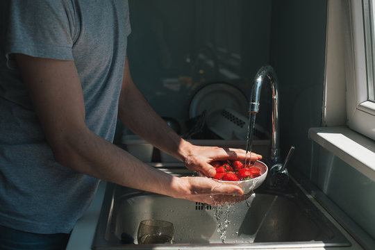 Man rinsing strawberries