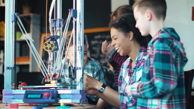 Group of kids in lab with teacher studying technology of 3d printing. Static 4K shot on Red cinema camera.