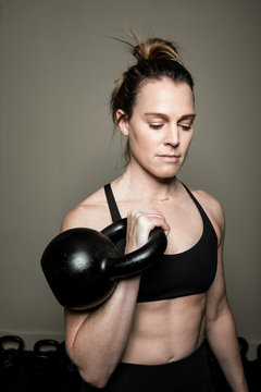 Woman working out in the home gym with kettle bell