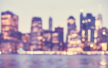 Blurred vintage toned picture of Manhattan skyline at dusk, abstract urban background, New York City, USA.