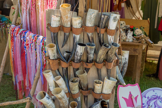 Horn cups and ribbons hang in a wall of a medieval market