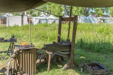 Medieval blacksmith fire with tools, charcoal, vise, blower and bellows