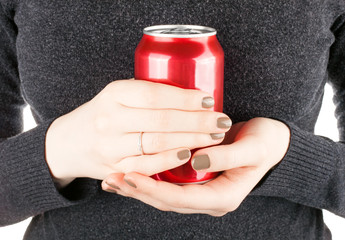 Female holding a closed can of soda