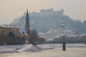The Salzach river and pedestrian bridge in Salzburg in back light, Austria, Europe. In the background the fortress Hohensalzburg.