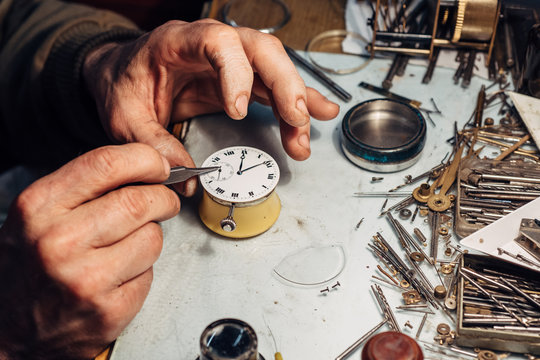 Watchmaker's hands repairing on an old pocket watch