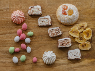 colored nuts and cookie and turkish delight and meringue wood texture