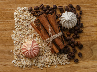 oatmeal and meringues and cinnamon sticks and coffee beans on wooden table