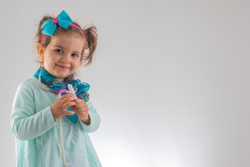 Cute kid girl playing doctor with toy at home