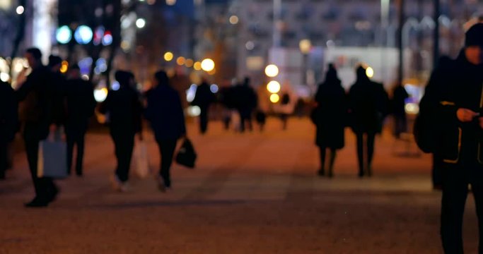 Unrecognizable people on the sidewalk. Evening n Warsaw.