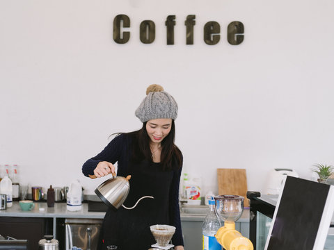 young charming woman making coffee in the kitchen