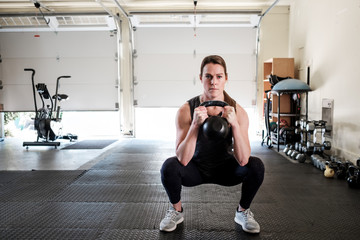 Woman working out in the home gym with kettle bell