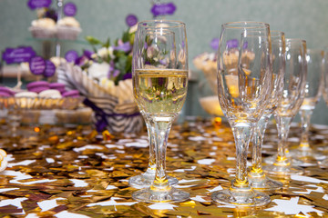 Glasses with champagne on the background of a festively decorated table with desserts