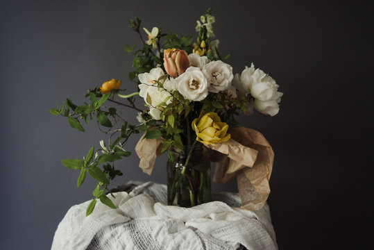 Organic spring bouquet of garden roses, tulips, peony and ranunculus on dark background