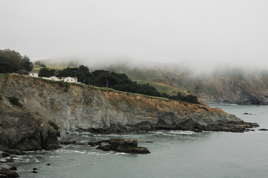 House on cliff next to ocean.