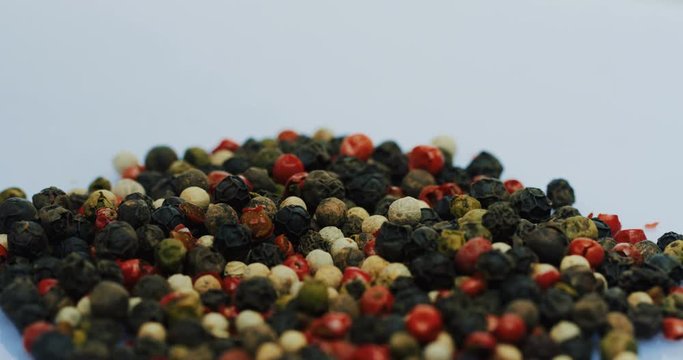 Close up of the different pepper peas faling down on the white surface. Macro shooting