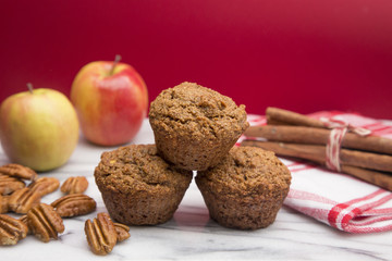 Apple Cinnamon Pecan Muffins on an Apple Red Background