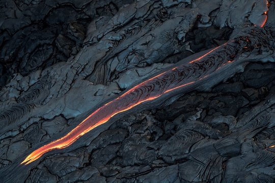 Aerial photo of lava flow, diagonally crossing the image like a finger pointing down