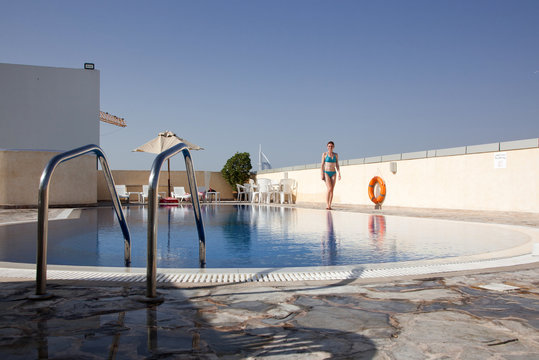 woman near rooftop swimmig pool in Dubai