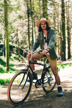Portrait of a young man on a bike on the woods.