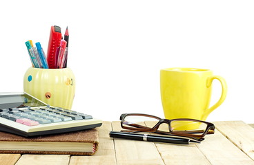 Eye glasses and financial calculator on book stack set on wooden working table with white isolated background