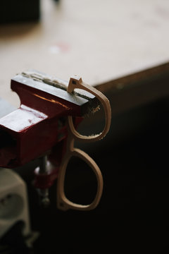 Close up of a bench vice with a frame glasses clamped in the atelier
