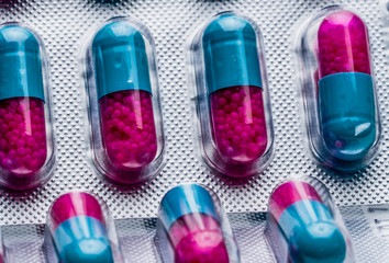 Macro shot detail of blue, pink capsule with granule in side pills. Pills in blister pack....