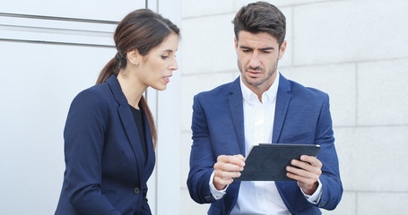 Businessman and woman working on tablet computer together