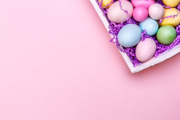 Fototapeta na wymiar Multicolor eggs in a white tray. Creative Easter concept. Modern solid pink background.
