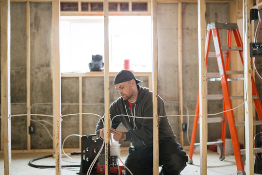 Electrician man installing wire on jobsite