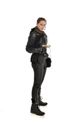 full length portrait of female  soldier wearing black  tactical armour, holding a gun, isolated on white studio background.