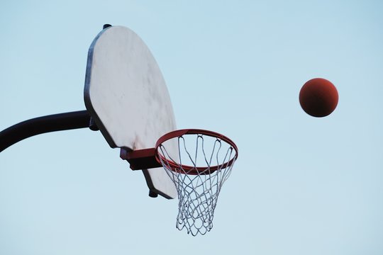 Low angle view of basketball and basketball hoop against clear sky