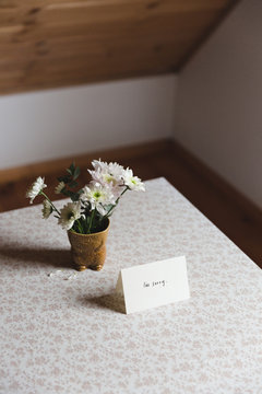 Card next to flowers on a table