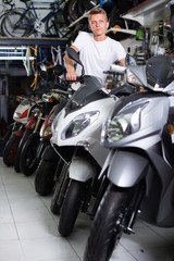 Fototapeta na wymiar man motorcyclist choosing the bike in the shop