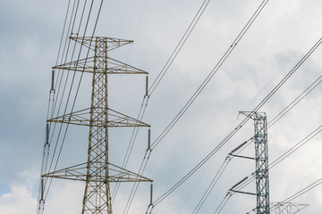 High voltage powerlines tower with cloudy and blue sky in background