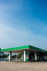 Fototapeta na wymiar Gas station with green theme color in broad daylight in sunny day and blue sky