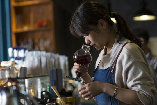 One young asian woman making caffee in the cafe