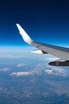 Wingtip of aircraft in flight feature the winglet with mountain in background
