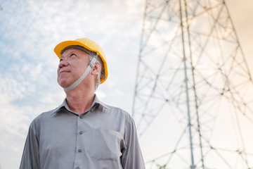 Engineer inspecting the high voltage power grid by using tablet as a tools