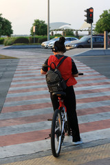 Cycliste sur un passage piéton. Abou Dhabi. Emirats Arabes Unis. / Cyclist on a pedestrian crossing. Emirate of Abu Dhabi.