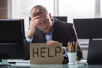 Businessman Holding Cardboard With Help Text