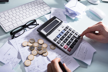 Businessperson Calculating Receipt With Calculator