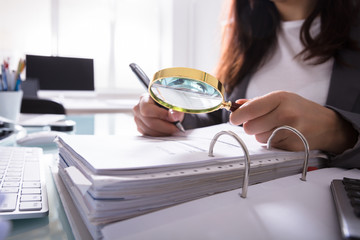 Businesswoman Checking Bill Through Magnifying Glass