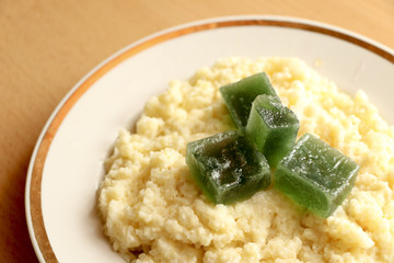 useful breakfast. wheat porridge with marmalade. golden gruel from millet with pieces of fresh fruit jelly.