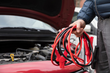 Close-up Of A Person Holding Jumper Cables