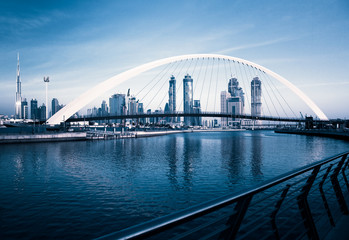 DUBAI, UAE - FEBRUARY 2018: Colorful sunset over Dubai Downtown skyscrapers and the newly built Tolerance bridge as viewed from the Dubai water canal.
