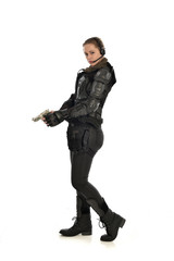 Fototapeta premium full length portrait of female soldier wearing black tactical armour, holding a gun, isolated on white studio background.