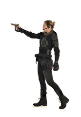 Fototapeta na wymiar full length portrait of female soldier wearing black tactical armour, holding a gun, isolated on white studio background.