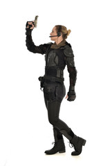 full length portrait of female  soldier wearing black  tactical armour, holding a gun, isolated on white studio background.