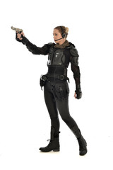 Fototapeta premium full length portrait of female soldier wearing black tactical armour, holding a gun, isolated on white studio background.