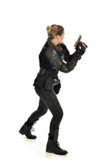 full length portrait of female  soldier wearing black  tactical armour, holding a gun, isolated on white studio background.